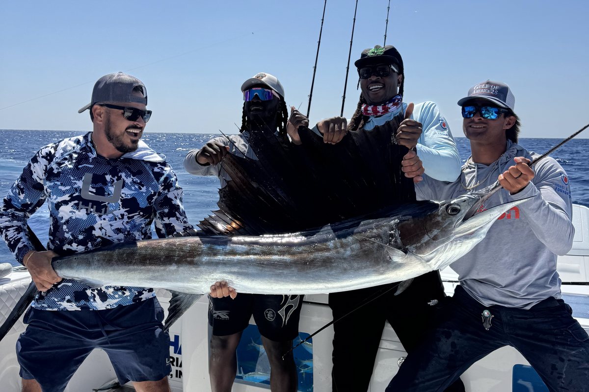 James Marko, Sterling Thomas, DeAndre Hopkins and Jason holding up a sailfish on deck